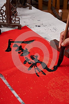 An old calligrapher writes couplets during the Chinese Year of the Dragon.