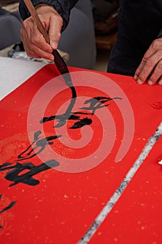 An old calligrapher writes couplets during the Chinese Year of the Dragon.