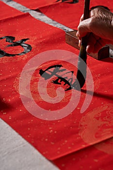 An old calligrapher writes couplets during the Chinese Year of the Dragon.