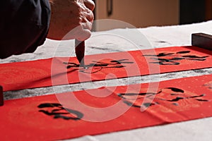 An old calligrapher writes couplets during the Chinese Year of the Dragon.