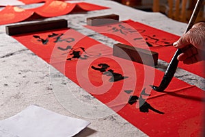 An old calligrapher writes couplets during the Chinese Year of the Dragon.