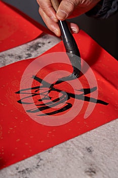 An old calligrapher writes couplets during the Chinese Year of the Dragon.