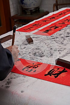 An old calligrapher writes couplets during the Chinese Year of the Dragon.