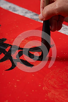 An old calligrapher writes couplets during the Chinese Year of the Dragon.