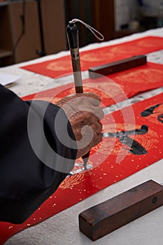 An old calligrapher writes couplets during the Chinese Year of the Dragon. photo