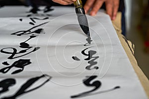 An old calligrapher is writing and creating calligraphy works.