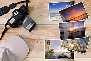 Old camera, cap and stack of photos on wooden background