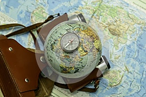 an old camera on a geographical map of the world instead of a globe lens the concept of travel tourism