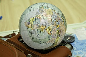 an old camera on a geographical map of the world instead of a globe lens the concept of travel tourism