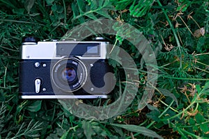 Old camera on green grass background