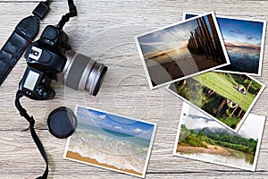 Old camera and stack of photos on vintage grunge wooden background