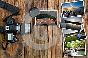 Old camera and stack of photos on vintage grunge wooden background