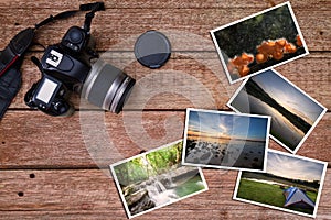 Old camera and stack of photos on vintage grunge wooden background