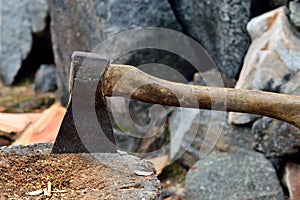 Old camping ax stuck into a tree stump