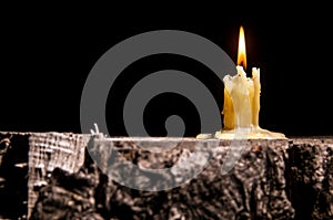 Old candle on the black background