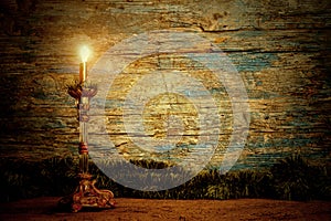 Old candle lit wooden background. Copy space