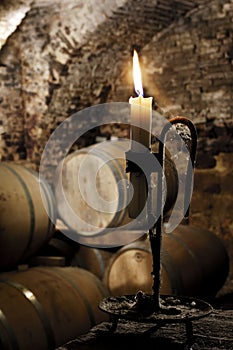 Old candle in a wine barrel cellar