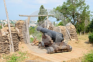 old cannon with fortifications on a hill on a summer day