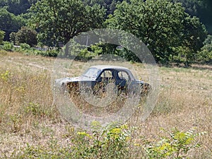 old car abandoned in a field, sensation of solitude