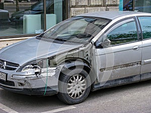 Old car after an accident. Dismantled wing, damaged mirror and front door