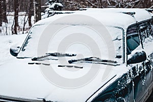 Old car covered with snow, driving in snowy weather