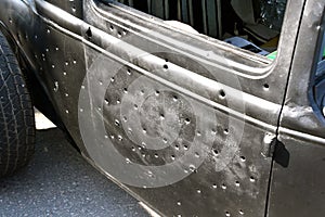 Old car door is riddled with bullet holes