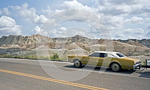 Old car driving in Badlands National Park