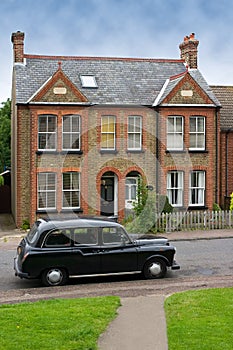 Old car in front of a typical house in Harlow, UK