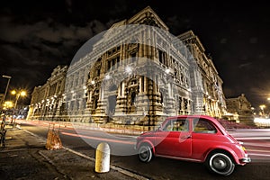 Old car Italian red by night. Italian historic monument