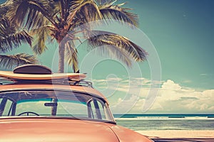 An old car parked on a tropical beach with a surfboard on the roof