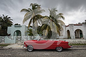 Old car on streets of Havana with beatiful palm trees in background. Cuba photo