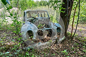 Old car wreck left to rust in the forest