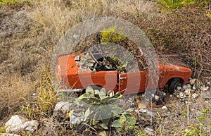 Old car wreck standing beside a road down the hill in andalusia.