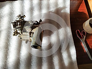 Old carburetor for a car engine with tools on table