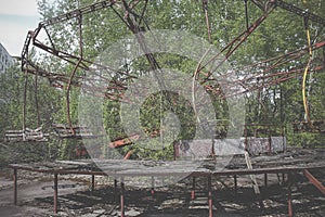 Old carousel in the ghost town of Pripyat. Abandoned city overgrown with trees