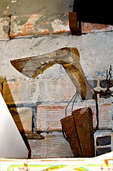 Old carpenter`s ax inserted in an exposed brick wall