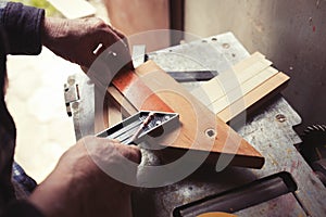 Old carpenter taking measurement of a wooden plank