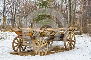 The old cart, carriage, not hitched to a horse, stands in a snow-covered field.