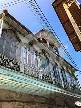 Old carved beautiful antique balcony of a wooden european house. European old architecture. Vertical photo