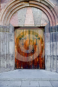 Old carved wooden church door with hinges.