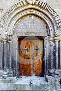 Old carved wooden church door with hinges.