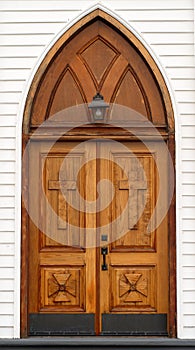 Old carved wooden church door with lantern