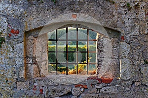 Old castle barred window with view to fall landscape