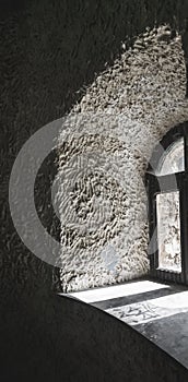 In an old castle, a window shines into a dark room inside