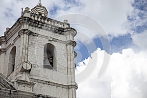 Old catholic church. White stone bell tower on blue sky background. Basilica de Santo Nino in Cebu photo