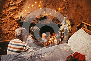 Old caucasian couple keeping hands warm at home. Senior aged husband and wife relaxing while opening palm of hands for warming at