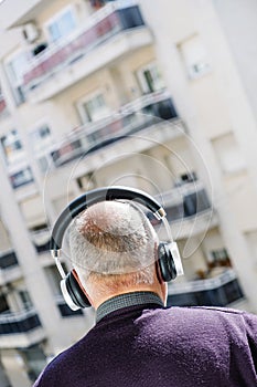 Old caucasian man using headphones
