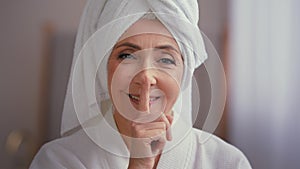 Old Caucasian middle-aged woman mature lady elderly model female with towel on head in bathrobe looking at camera