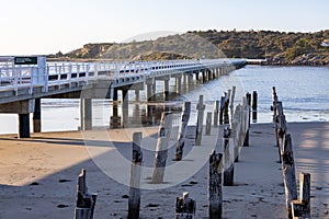 The old causeway ruins and the new causeway between Victor Harbor and Granite island on a bright sunny day in South Australia on