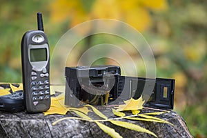 Old cellular phone and film camera. Mobile telephone from 90`s and camera from 80`s.